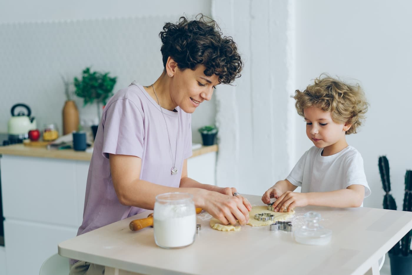 A mother and young child cooking together at home.