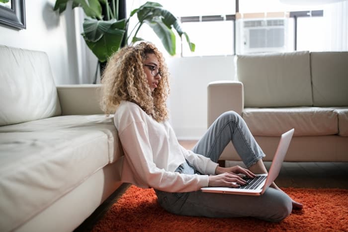 A person sitting comfortably at home with a laptop, in a private and relaxed setting.